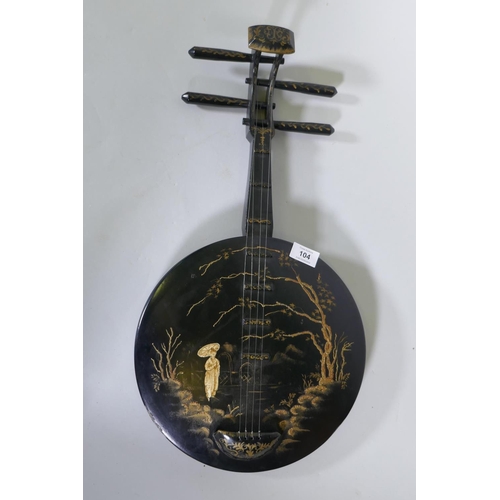 104 - A wood wall ornament with raised decoration, in the form of an Oriental stringed musical instrument,... 