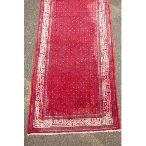 1051 - A Persian red ground wool Sarouk Mir rug, 208 x 108cm