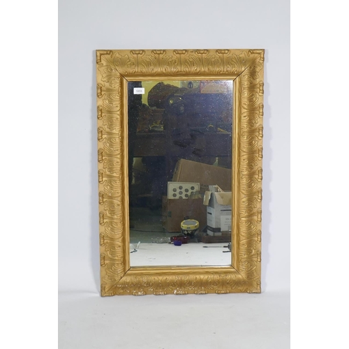 1055 - An antique carved giltwood framed wall mirror, 61 x 92cm