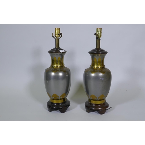 106 - A pair of white metal table lamps with brass Oriental style lotus leaf decoration, on wood bases,54c... 