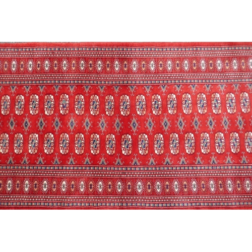 1068 - A rich red ground fine woven Bokhara runner, 98 x 364cm