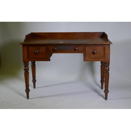 1069 - Early C19th mahogany kneehole desk of three drawers, with three quarter gallery top, raised on turne... 