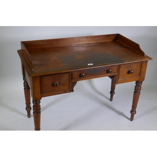 1069 - Early C19th mahogany kneehole desk of three drawers, with three quarter gallery top, raised on turne... 