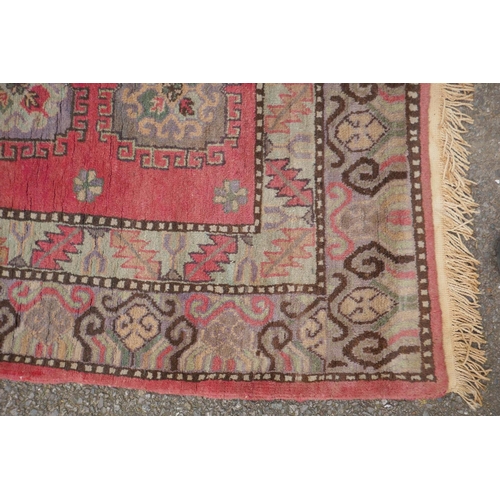 1072 - A hand woven Caucasian carpet with a bespoke all over Bokharra design on a salmon pink ground, 185 x... 