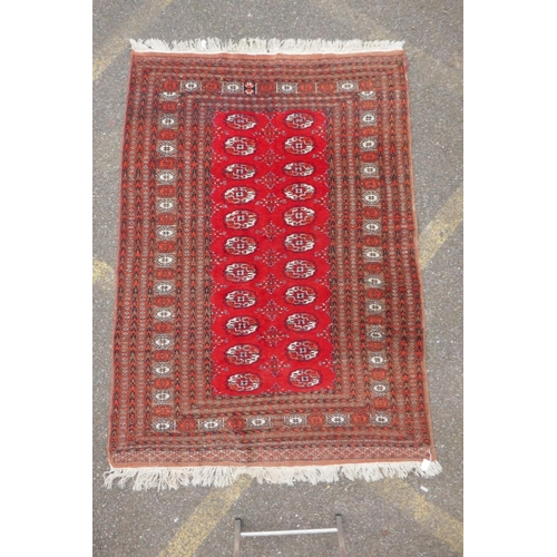 1078 - A red ground Bokhara rug with brown and orange borders, 128 x 175cm