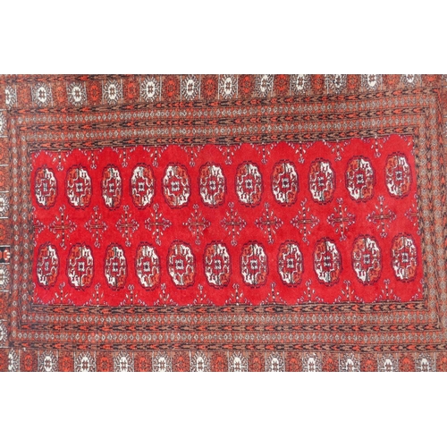 1078 - A red ground Bokhara rug with brown and orange borders, 128 x 175cm