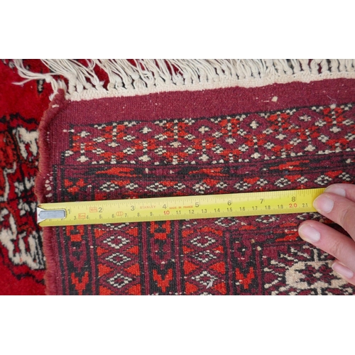 1078 - A red ground Bokhara rug with brown and orange borders, 128 x 175cm