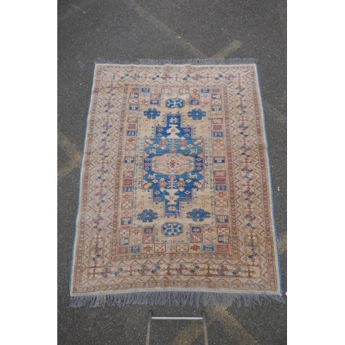 1079 - A Turkish gold ground wool rug with a blue geometric medallion design, 164 x 212cm