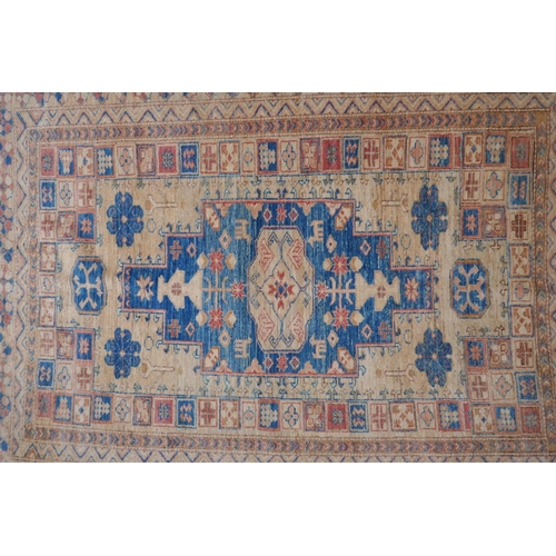 1079 - A Turkish gold ground wool rug with a blue geometric medallion design, 164 x 212cm