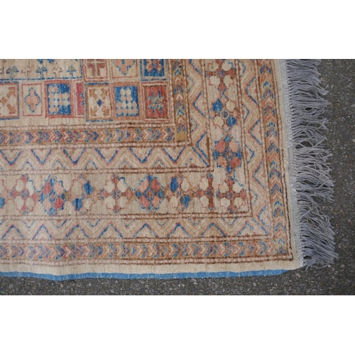 1079 - A Turkish gold ground wool rug with a blue geometric medallion design, 164 x 212cm