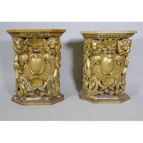 1084 - A pair of early C19th carved and giltwood pine pedestals/stands, decorated with winged putti and she... 