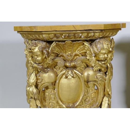 1084 - A pair of early C19th carved and giltwood pine pedestals/stands, decorated with winged putti and she... 