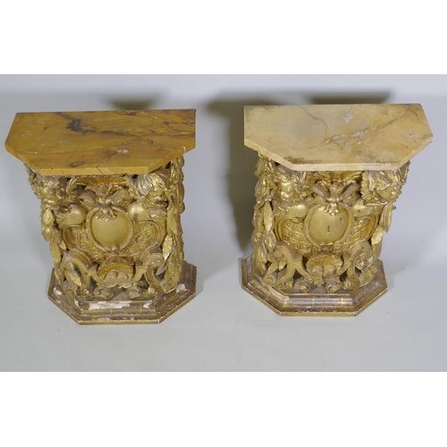 1084 - A pair of early C19th carved and giltwood pine pedestals/stands, decorated with winged putti and she... 