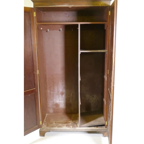 1085 - A late C19th/early C20th mahogany two door wardrobe/cupboard, with panelled doors, raised on bracket... 