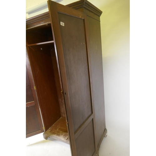 1085 - A late C19th/early C20th mahogany two door wardrobe/cupboard, with panelled doors, raised on bracket... 