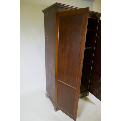 1085 - A late C19th/early C20th mahogany two door wardrobe/cupboard, with panelled doors, raised on bracket... 