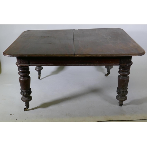 1087 - A Victorian mahogany pull out extending dining table raised on turned supports with carved decoratio... 