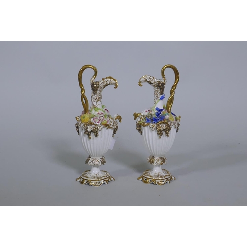 109 - A pair of Continental hard paste porcelain ewers with fine applied floral decoration and gilded high... 