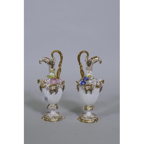 109 - A pair of Continental hard paste porcelain ewers with fine applied floral decoration and gilded high... 