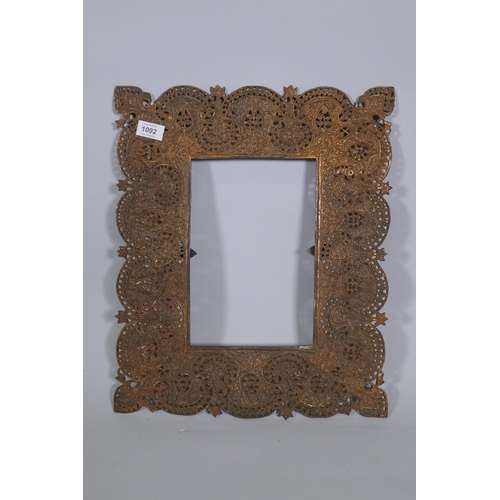 1092 - An Indian copper mirror frame with pierced and engraved decoration