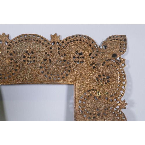 1092 - An Indian copper mirror frame with pierced and engraved decoration