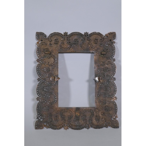 1092 - An Indian copper mirror frame with pierced and engraved decoration