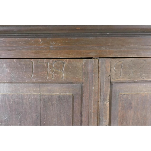 1101 - An early C18th two door cupboard with fielded panel doors and panelled sides, raised on a plinth bas... 