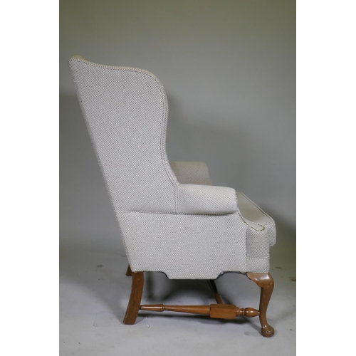 1117 - A good pair of Georgian style high back wing armchairs with wide seats, raised on walnut cabriole su... 