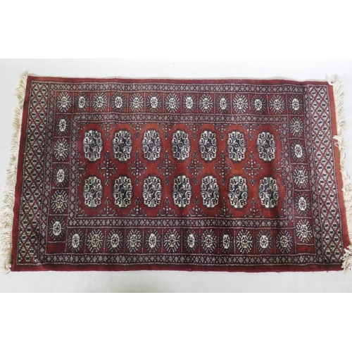 1131 - A Bokhara hand woven deep red ground rug with traditional pattern, 130 x 80cm