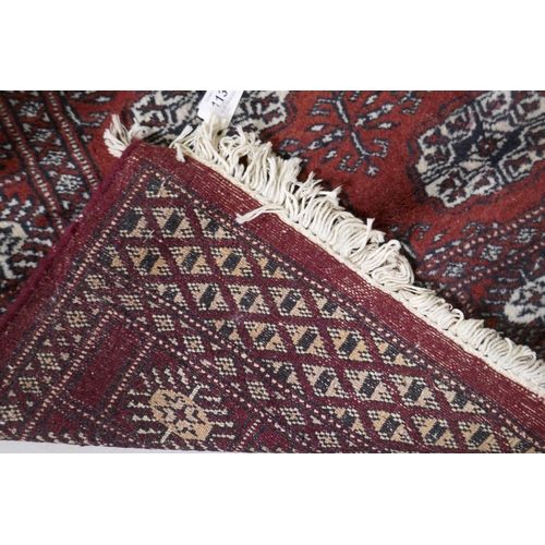 1131 - A Bokhara hand woven deep red ground rug with traditional pattern, 130 x 80cm