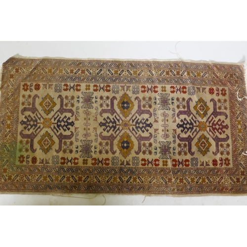 1136 - An antique hand woven Oriental rug with geometric designs n a buff coloured field, 68 x 125cm