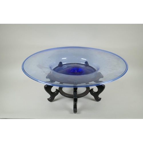 133 - A large Murano blue glass charger, on an associated Chinese hardwood stand, 63cm diameter