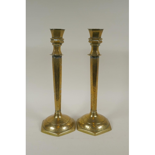 140 - A pair of Chinese brass hexagonal candlesticks with engraved floral decoration, 35cm high