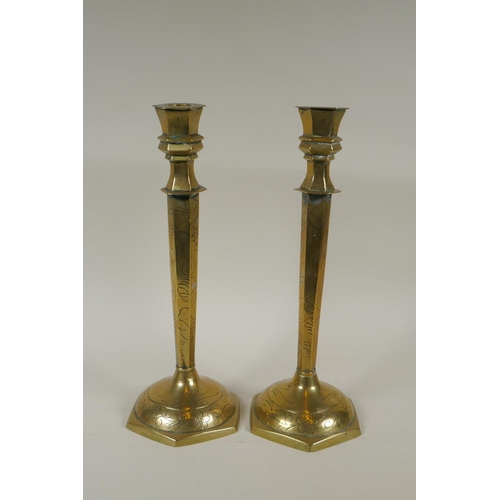 140 - A pair of Chinese brass hexagonal candlesticks with engraved floral decoration, 35cm high