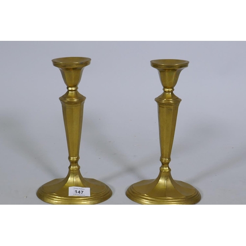 147 - A pair of antique brass candlesticks, 25cm high