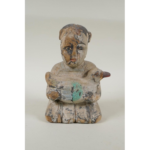 150 - A C19th carved and painted wood figure of a girl carrying a duck, with inset bone eyes, 21cm high