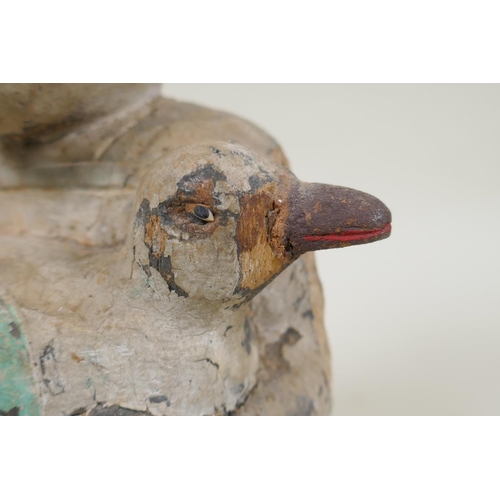 150 - A C19th carved and painted wood figure of a girl carrying a duck, with inset bone eyes, 21cm high