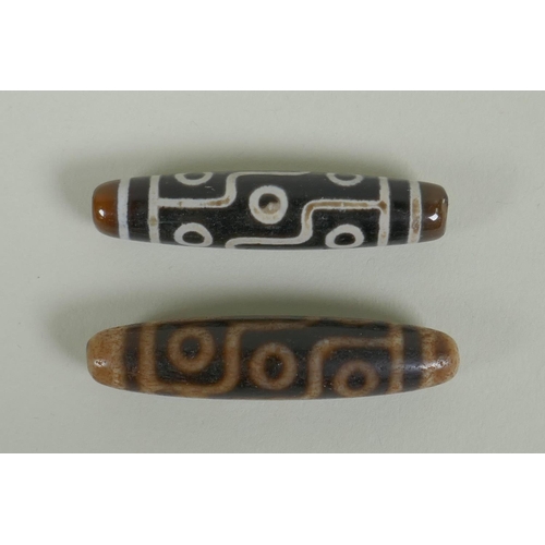 151 - A pair of Tibetan agate dzi beads, 5.5cm long