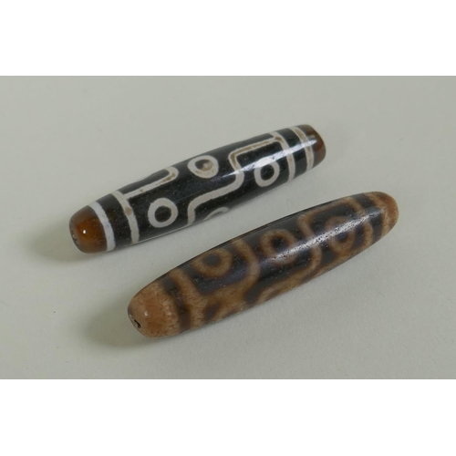 151 - A pair of Tibetan agate dzi beads, 5.5cm long