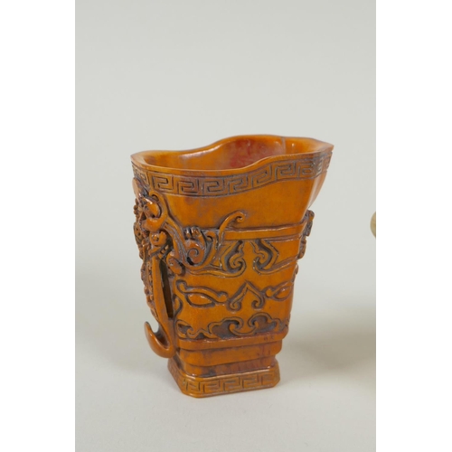 173 - A Chinese moulded glass libation cup in the form of a phoenix, and a carved bone libation cup with a... 