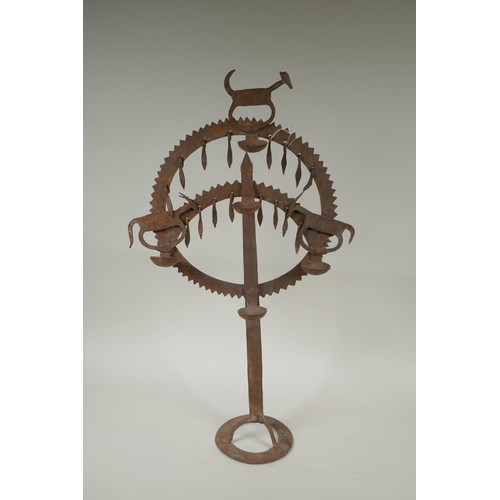 174 - An Indian wrought iron oil lamp with animal decoration, 61cm high