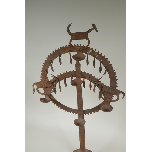 174 - An Indian wrought iron oil lamp with animal decoration, 61cm high