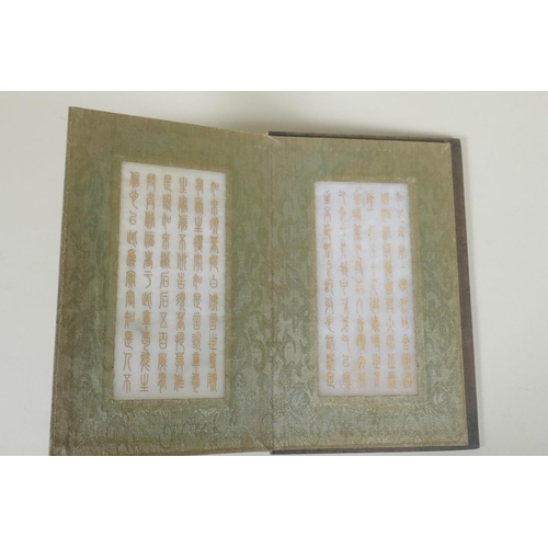 178 - A Chinese wood and silk bound book with white jade tablets bearing chased and gilt inscriptions, 22 ... 