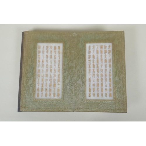 178 - A Chinese wood and silk bound book with white jade tablets bearing chased and gilt inscriptions, 22 ... 