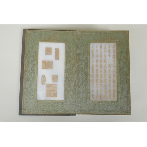 178 - A Chinese wood and silk bound book with white jade tablets bearing chased and gilt inscriptions, 22 ... 