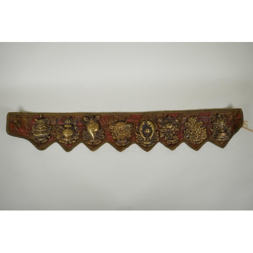 180 - A Tibetan silk and linen belt with bronze mounts depicting the eight Buddhist treasures, 72cm long