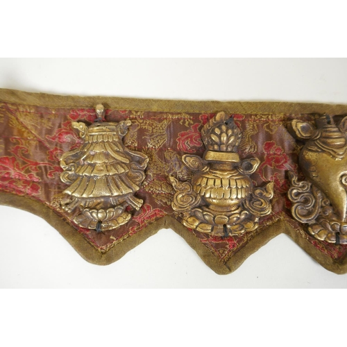 180 - A Tibetan silk and linen belt with bronze mounts depicting the eight Buddhist treasures, 72cm long