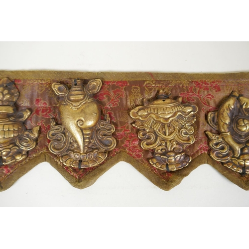 180 - A Tibetan silk and linen belt with bronze mounts depicting the eight Buddhist treasures, 72cm long