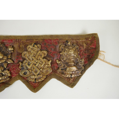 180 - A Tibetan silk and linen belt with bronze mounts depicting the eight Buddhist treasures, 72cm long