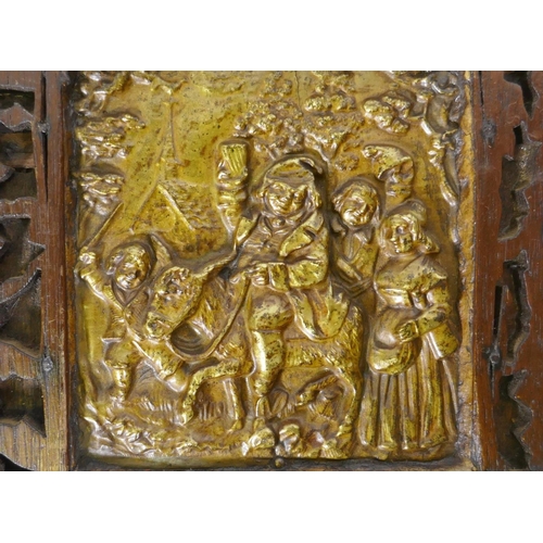 187 - An antique Folk Art wood panel with fret borders and metal mounts, the brass plaque with repousse de... 